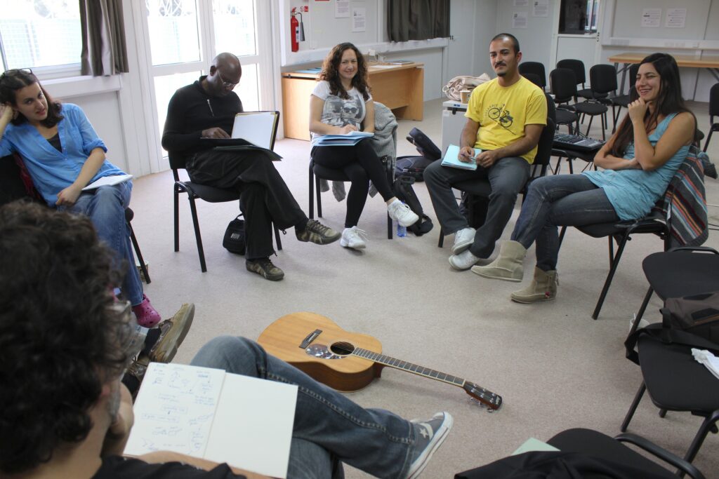 group of people sitting in chairs in a circle. 